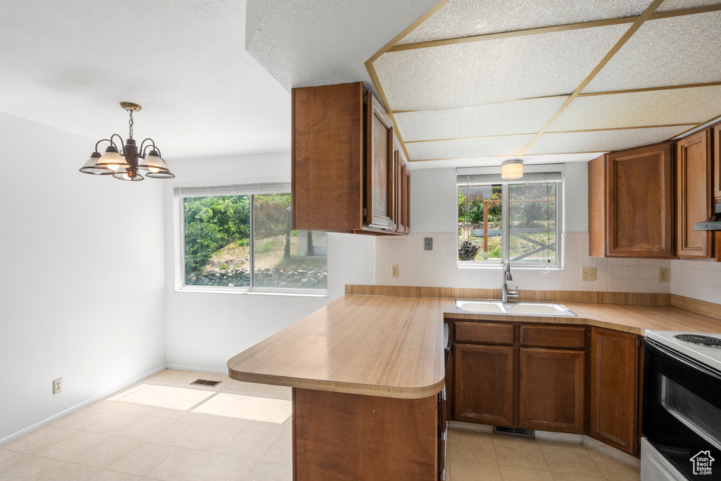 Kitchen with white range with electric stovetop, healthy amount of natural light, and light countertops