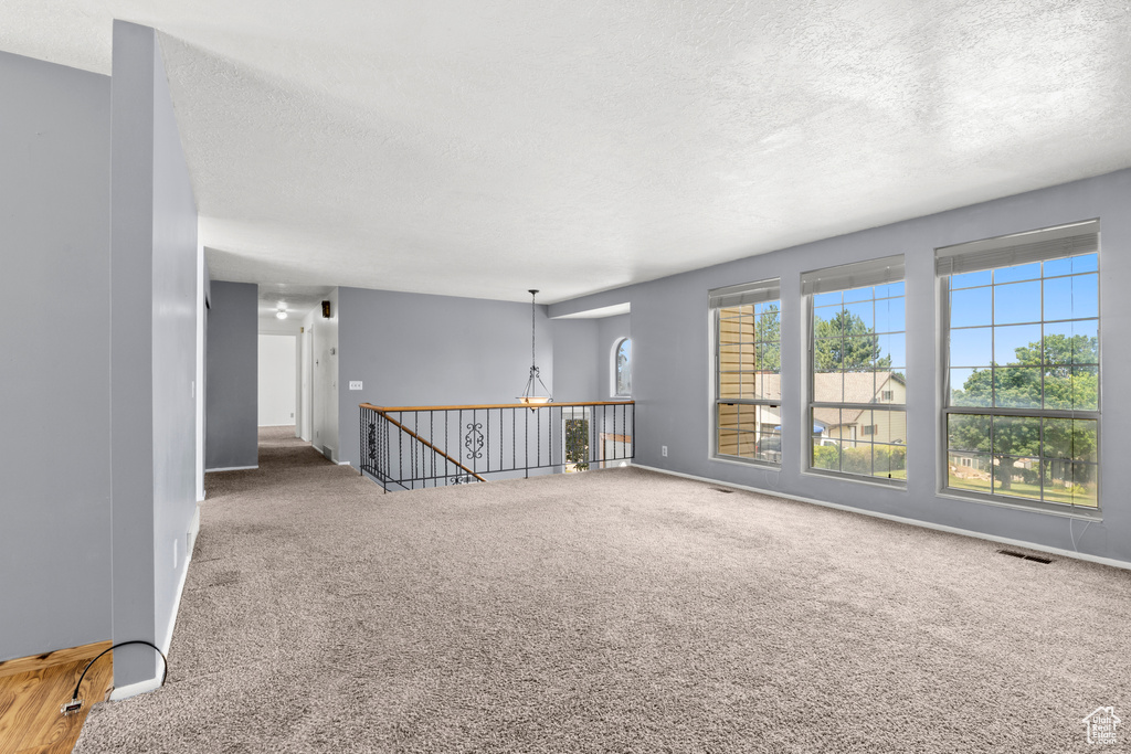 Spare room with a textured ceiling and carpet