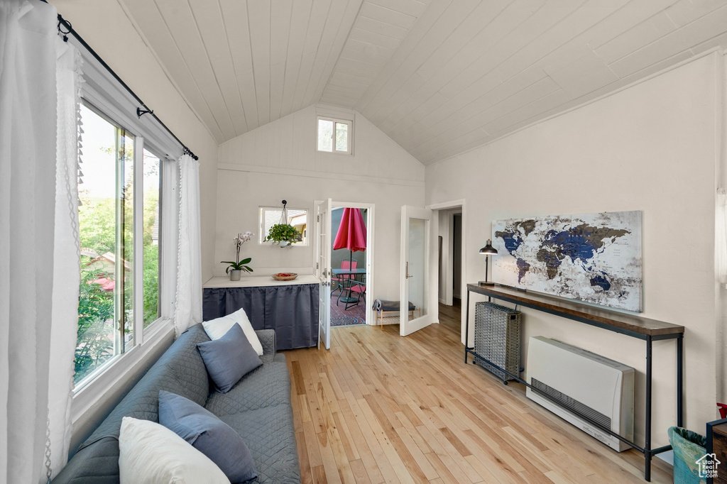 Living area featuring light wood-style floors, wooden ceiling, and high vaulted ceiling