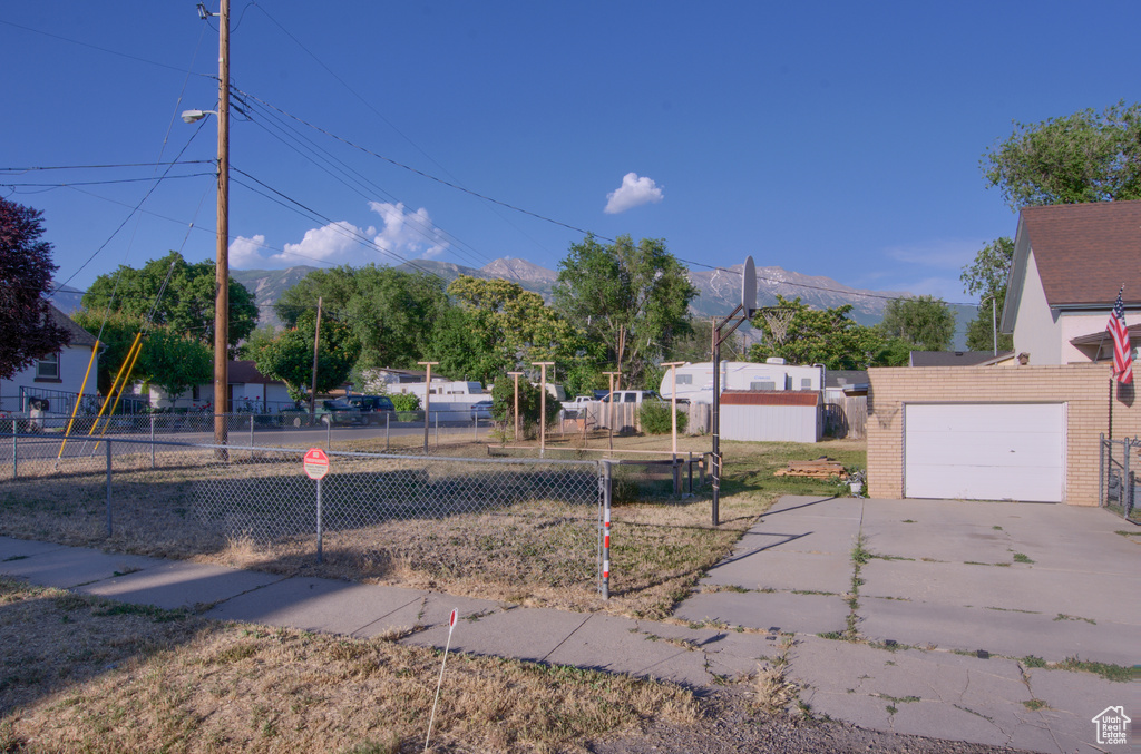 View of yard with a garage and concrete driveway