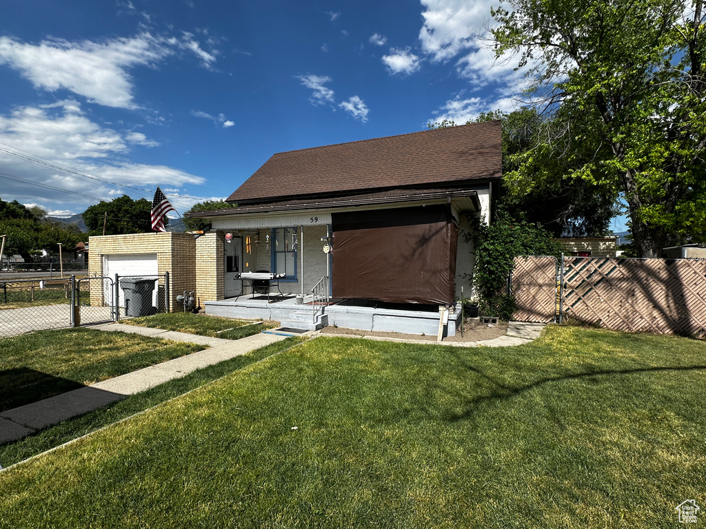 View of front facade featuring covered porch, a gate, driveway, and a shingled roof