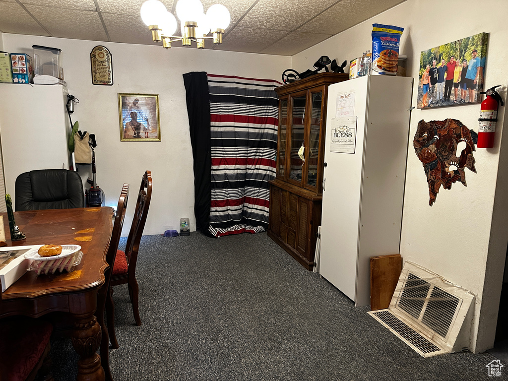 Office area with carpet, a chandelier, and a paneled ceiling