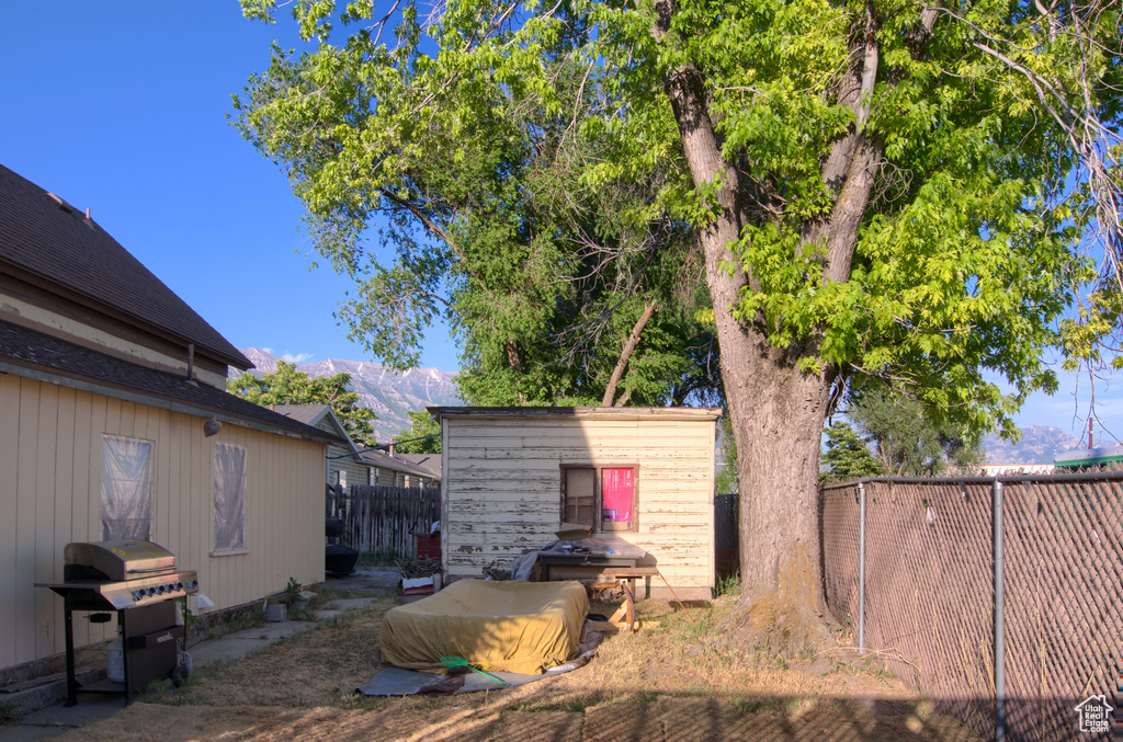 Fenced backyard with an outbuilding and a mountain view