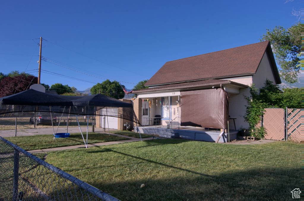 View of front of home featuring stucco siding and roof with shingles