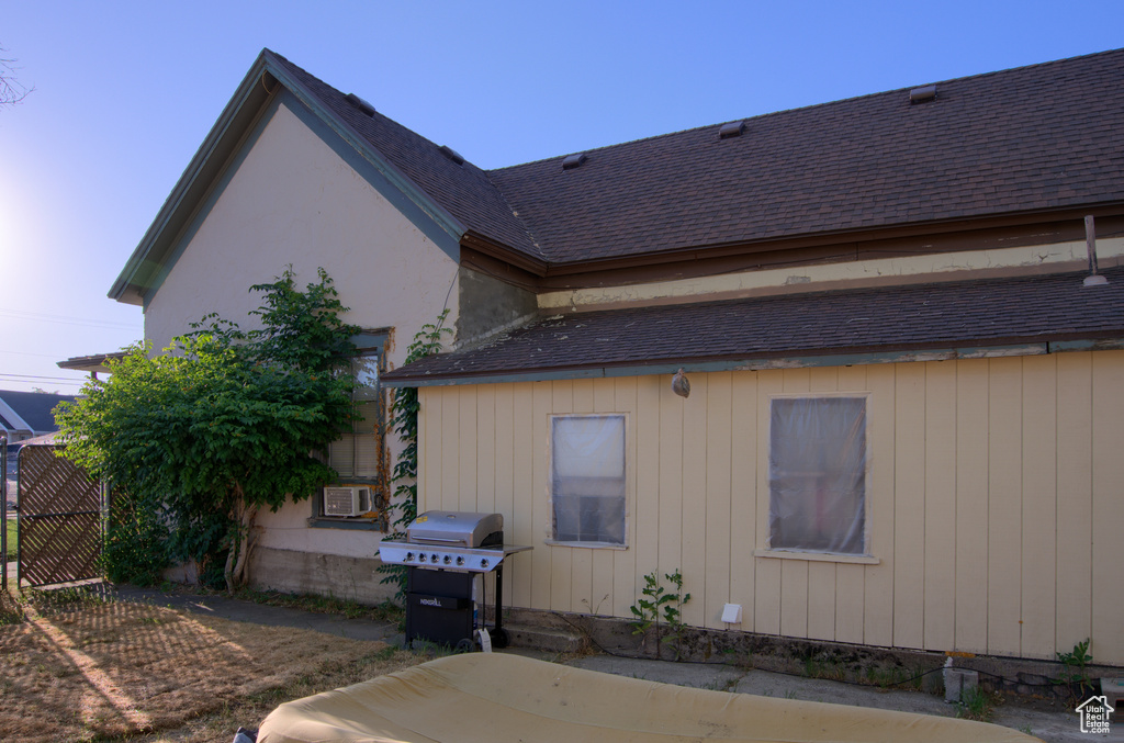 Rear view of property featuring roof with shingles
