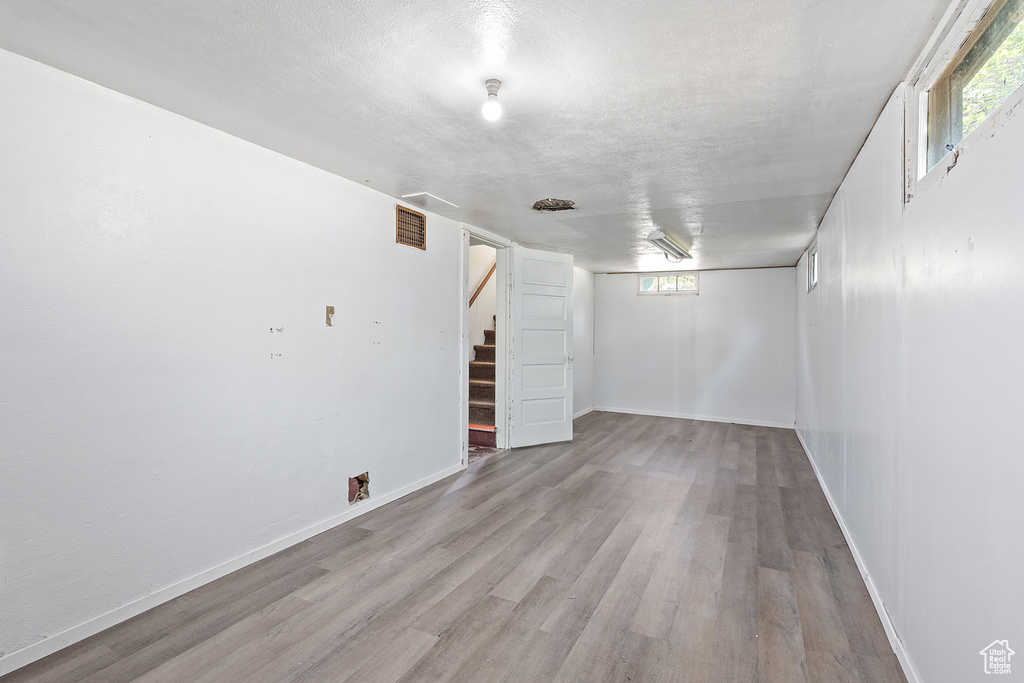 Basement with stairway, wood finished floors, and plenty of natural light