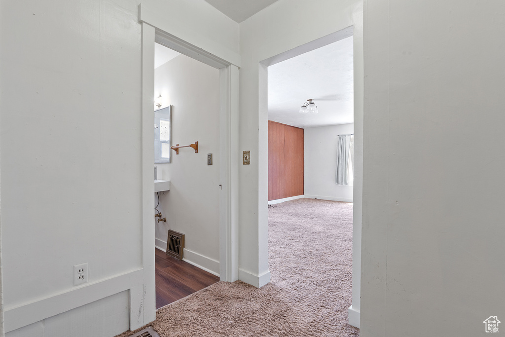 Hallway featuring carpet and baseboards
