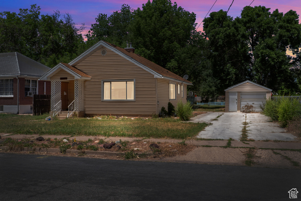View of front of property featuring a garage, an outdoor structure, entry steps, and driveway
