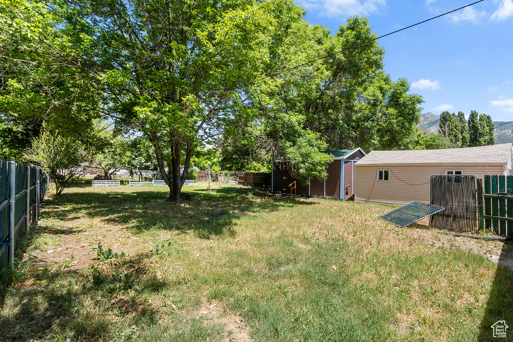 Fenced backyard with a storage shed and a mountain view