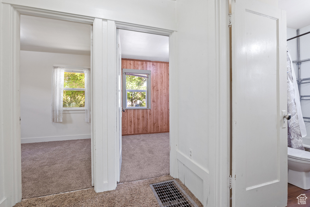 Hall with carpet floors and wood walls