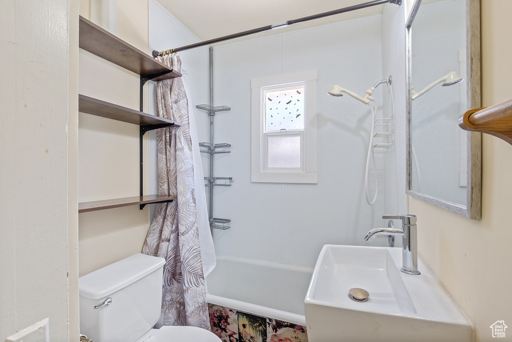 Bathroom featuring toilet and shower / bath combo