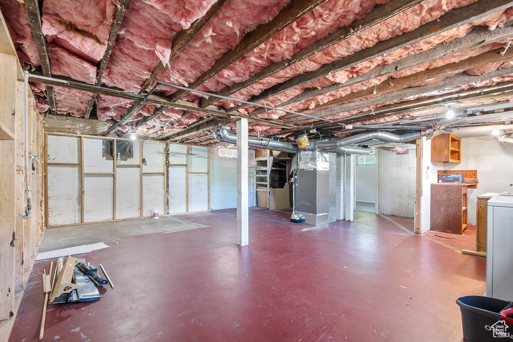 Below grade area featuring heating unit and washer / clothes dryer