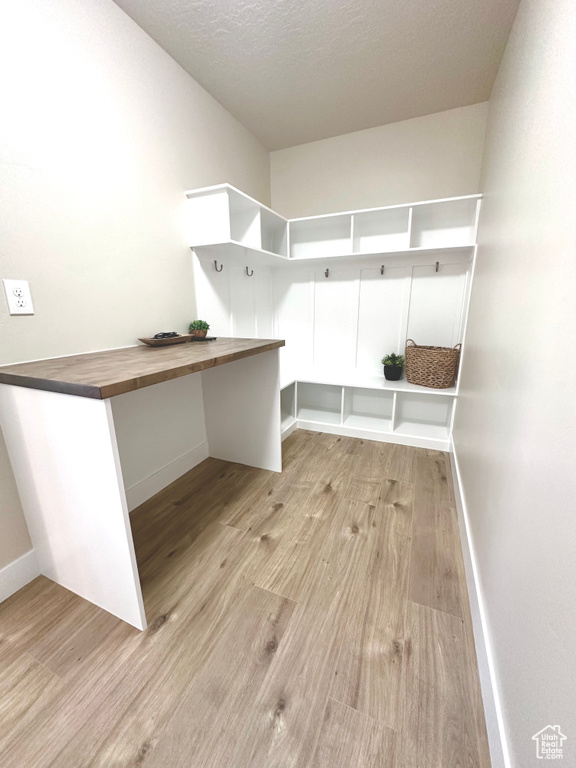 Mudroom with wood finished floors and a textured ceiling
