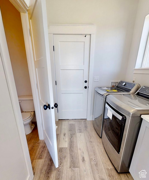 Laundry room featuring separate washer and dryer and light wood-type flooring