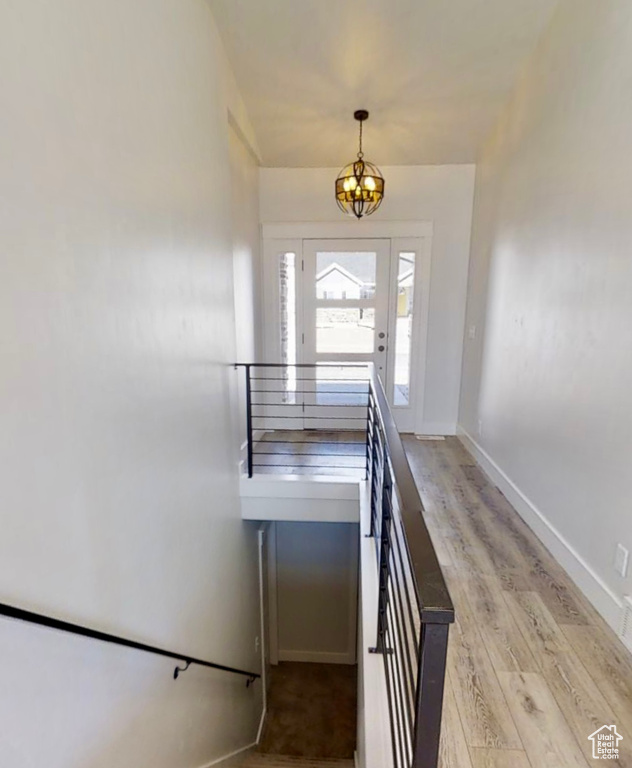 Stairway with a chandelier and wood finished floors