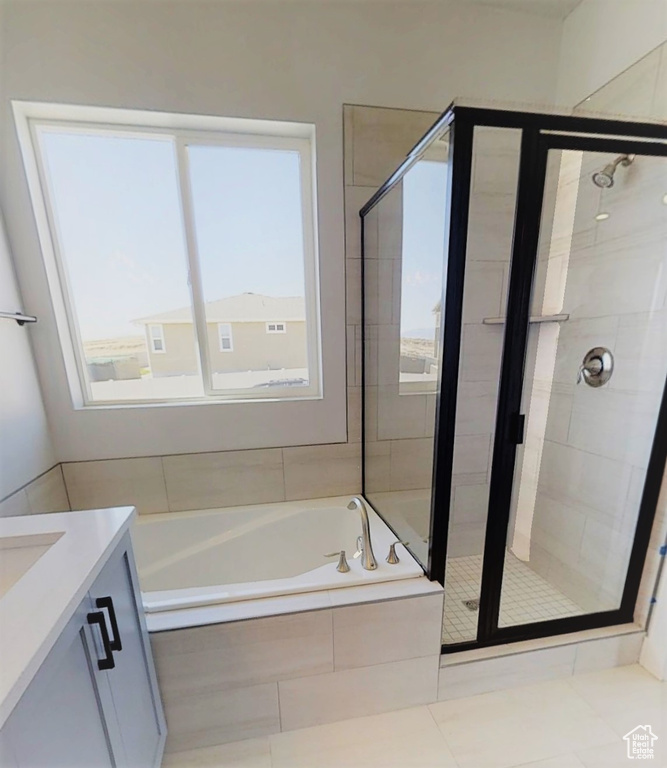 Bathroom featuring a garden tub, a shower stall, vanity, and tile patterned flooring