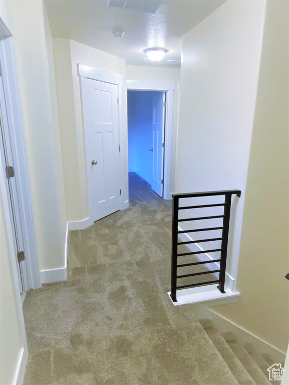 Hallway with carpet flooring and baseboards