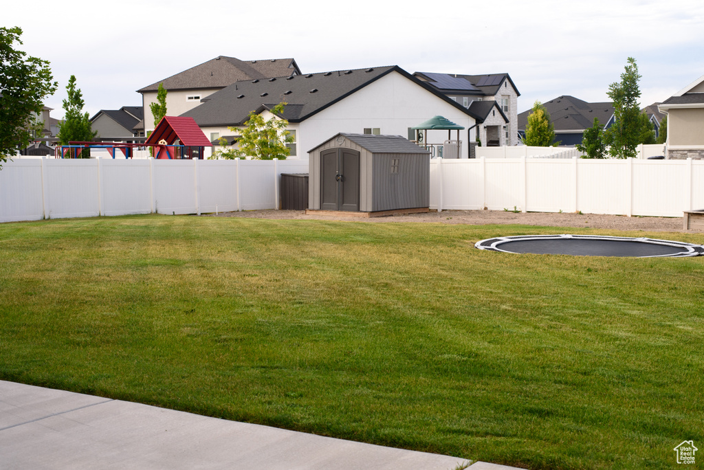 Fenced backyard with a shed and a residential view