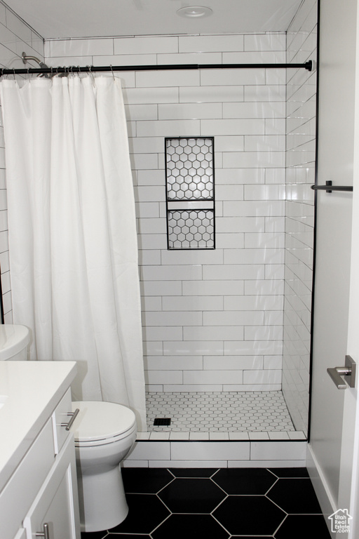 Full bath featuring vanity, a shower stall, and tile patterned floors