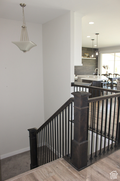 Stairs with wood finished floors and recessed lighting