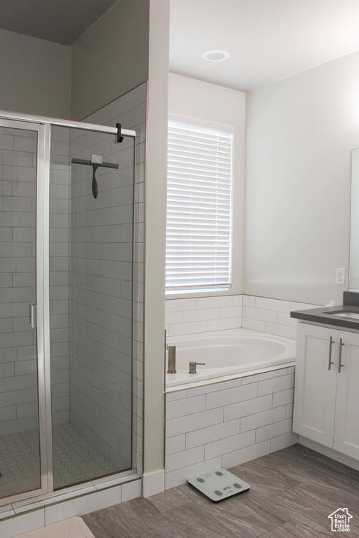 Bathroom with vanity, a bath, a shower stall, and wood finished floors