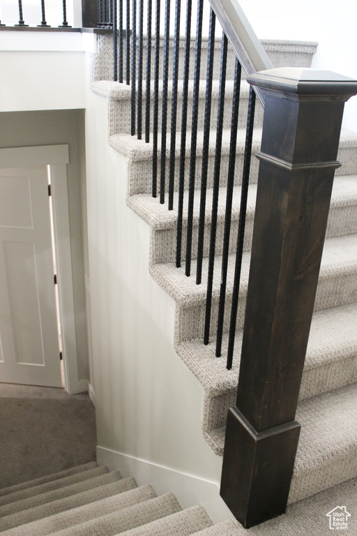 Stairway with baseboards and carpet floors