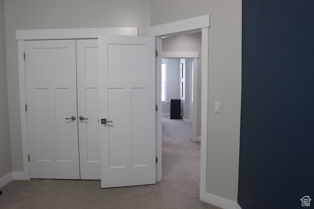 Unfurnished bedroom featuring light colored carpet and a closet