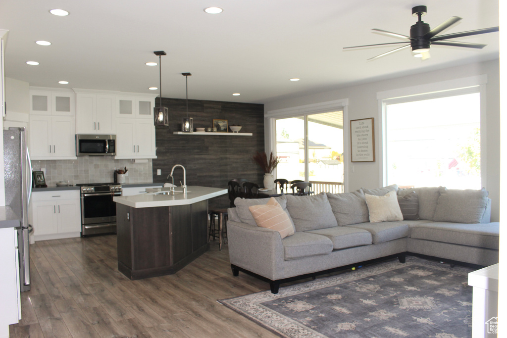 Living area featuring ceiling fan, dark wood-type flooring, and recessed lighting