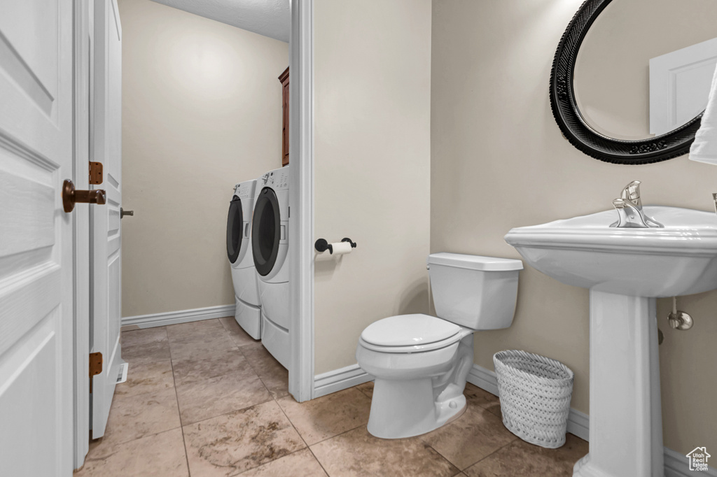 Bathroom with washing machine and dryer and toilet