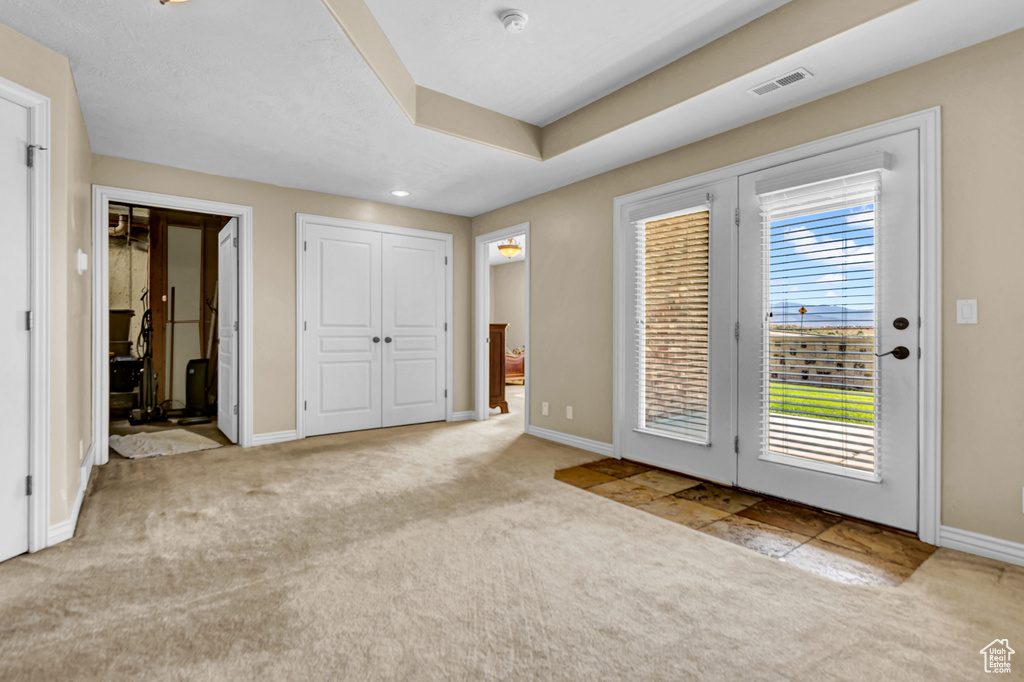 Unfurnished bedroom with carpet, access to outside, and ensuite bath