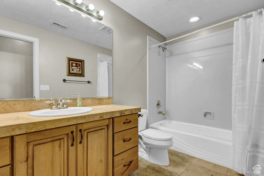 Full bathroom featuring vanity, shower / tub combo with curtain, and tile patterned flooring
