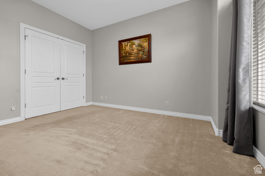 Unfurnished bedroom featuring carpet flooring and a closet