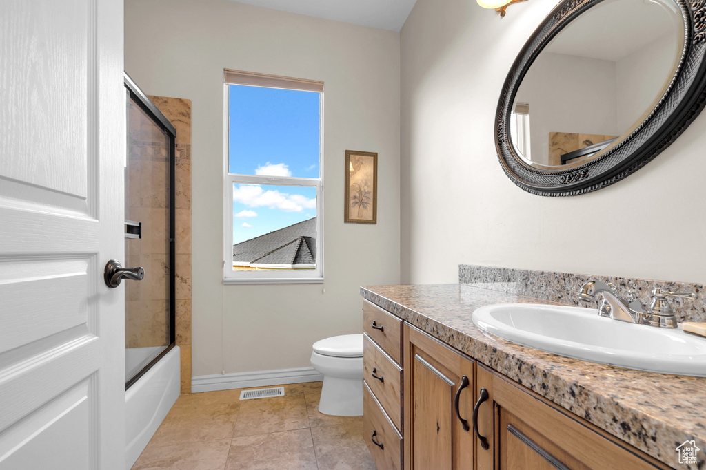 Full bathroom featuring vanity, enclosed tub / shower combo, and tile patterned flooring
