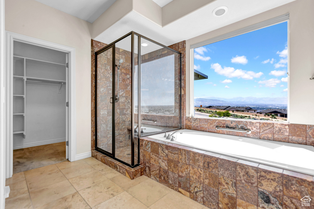 Bathroom with a garden tub, a stall shower, a walk in closet, and a mountain view