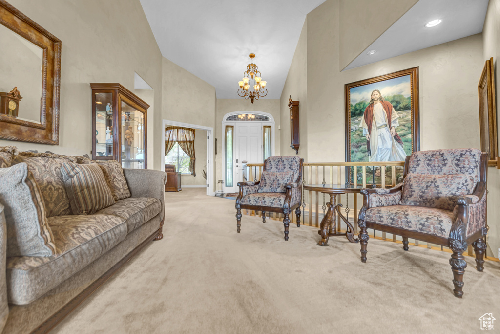 Living area featuring a chandelier, carpet, and high vaulted ceiling