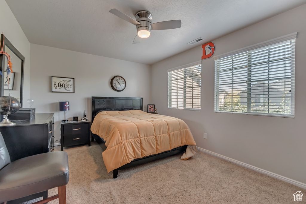 Bedroom featuring light colored carpet and ceiling fan