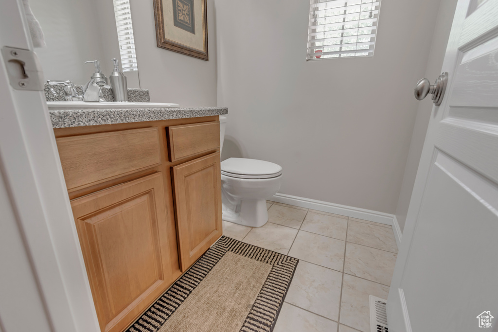 Half bathroom with vanity and tile patterned flooring
