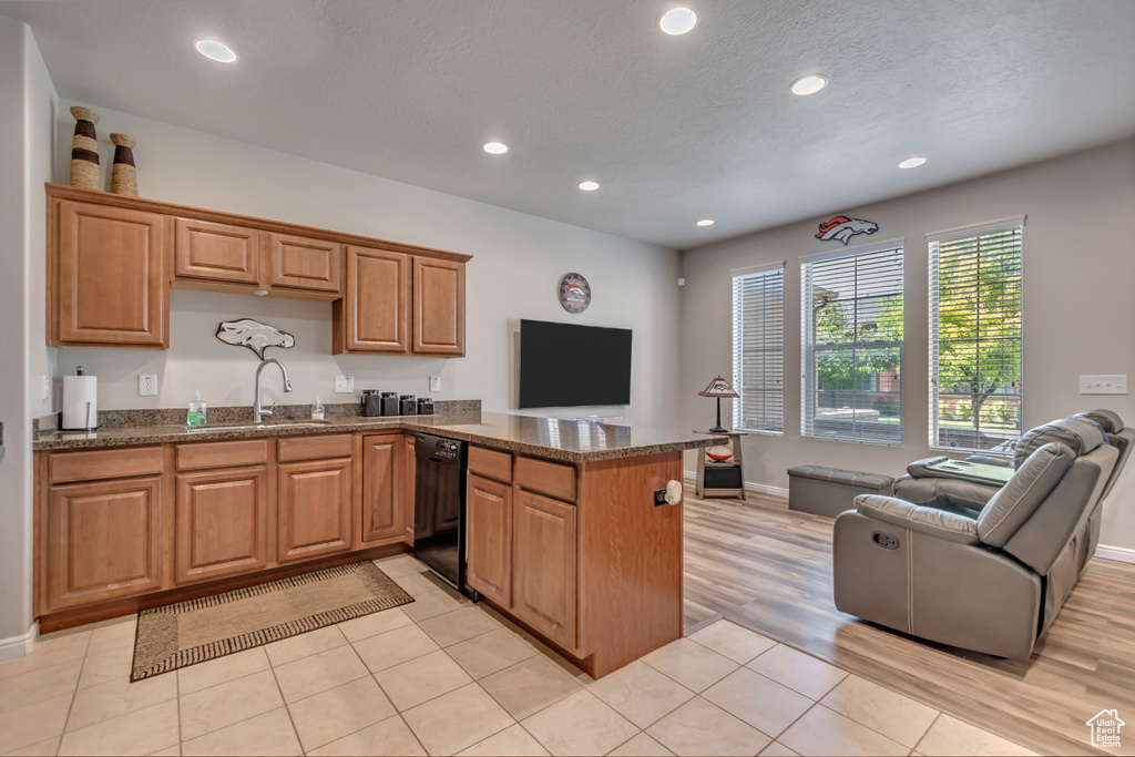 Kitchen with black dishwasher, open floor plan, a peninsula, recessed lighting, and light tile patterned floors