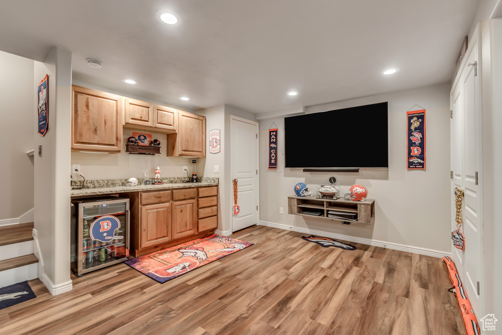 Indoor wet bar featuring beverage cooler, recessed lighting, and light wood-type flooring