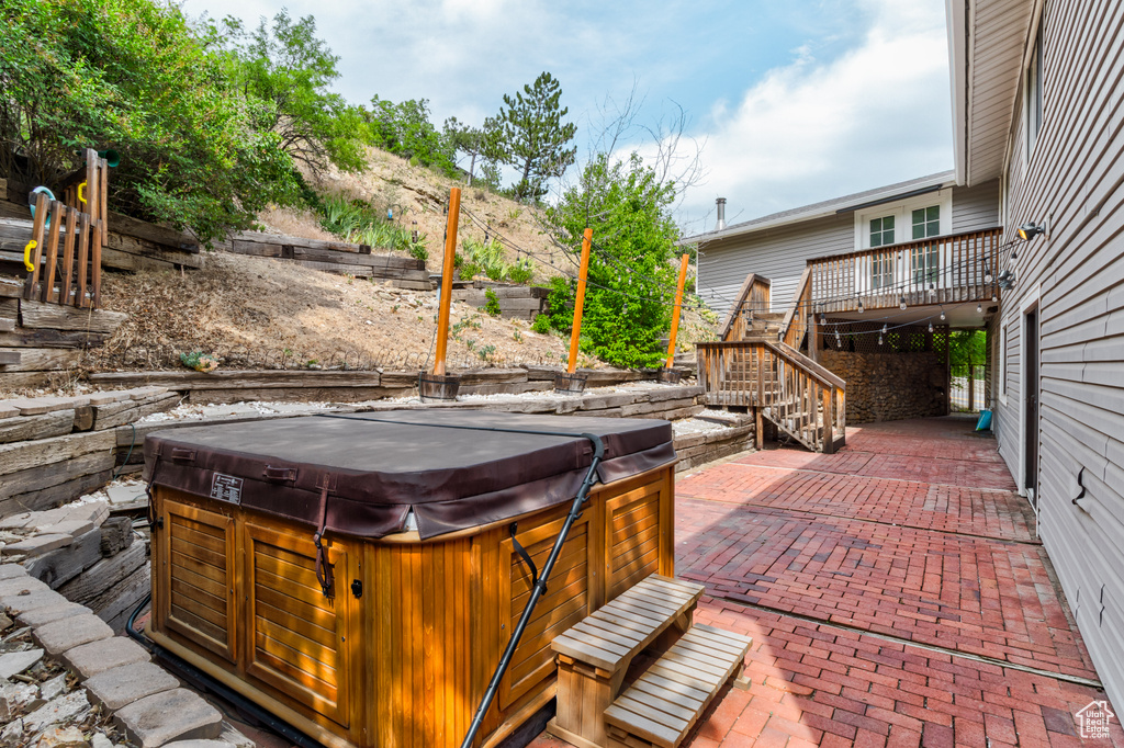 View of patio / terrace with a hot tub, stairway, and a deck