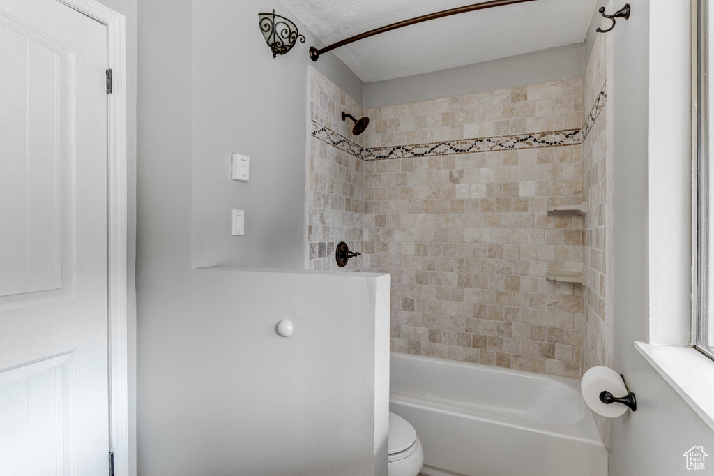 Full bathroom featuring shower / bath combination and toilet