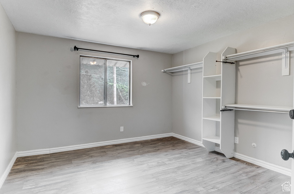 Walk in closet with wood finished floors