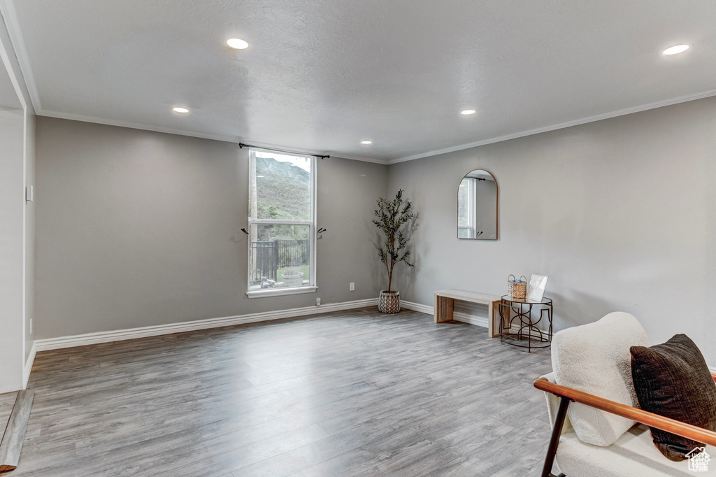 Sitting room featuring recessed lighting, wood finished floors, and ornamental molding