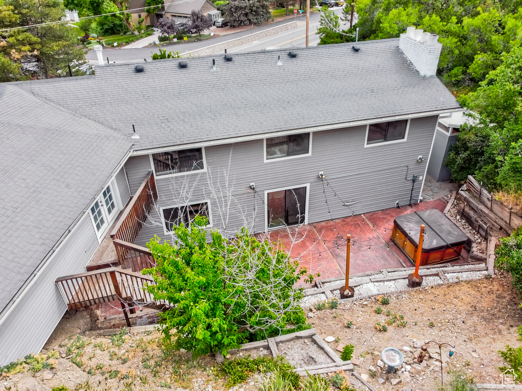 Back of property with a chimney, a patio, and a vegetable garden