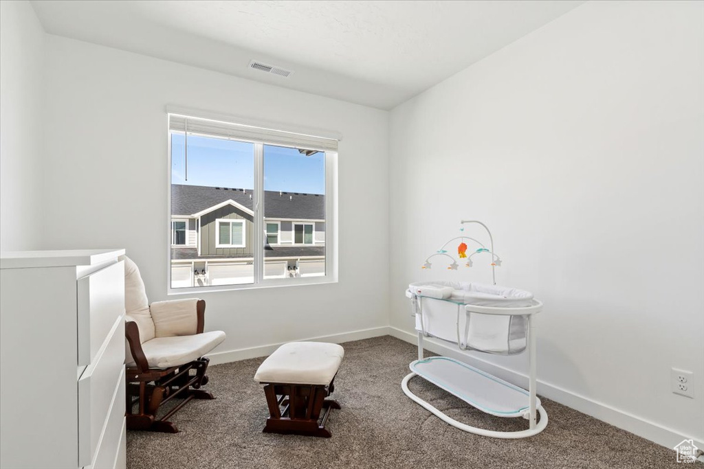 Sitting room featuring carpet flooring and baseboards