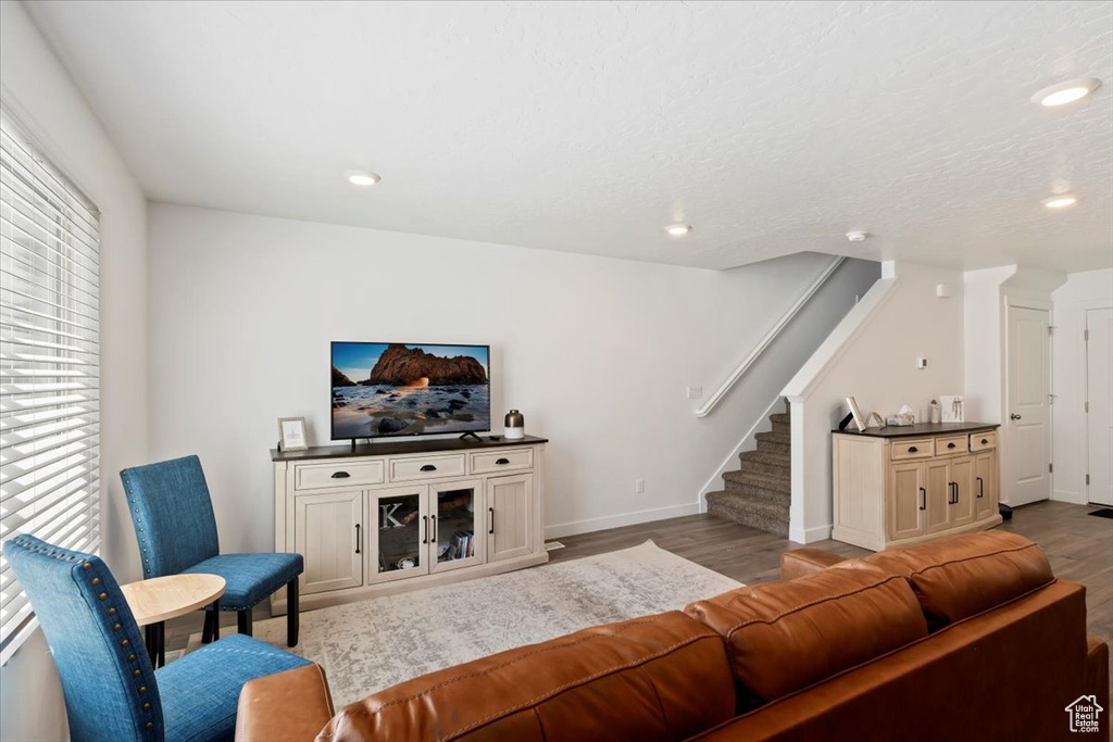 Living area featuring wood finished floors, stairway, and recessed lighting