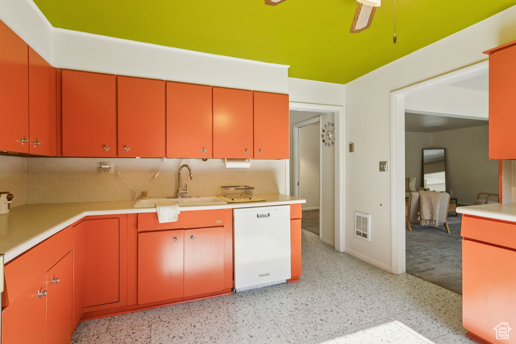 Kitchen with dishwasher, red cabinetry, light countertops, and light flooring