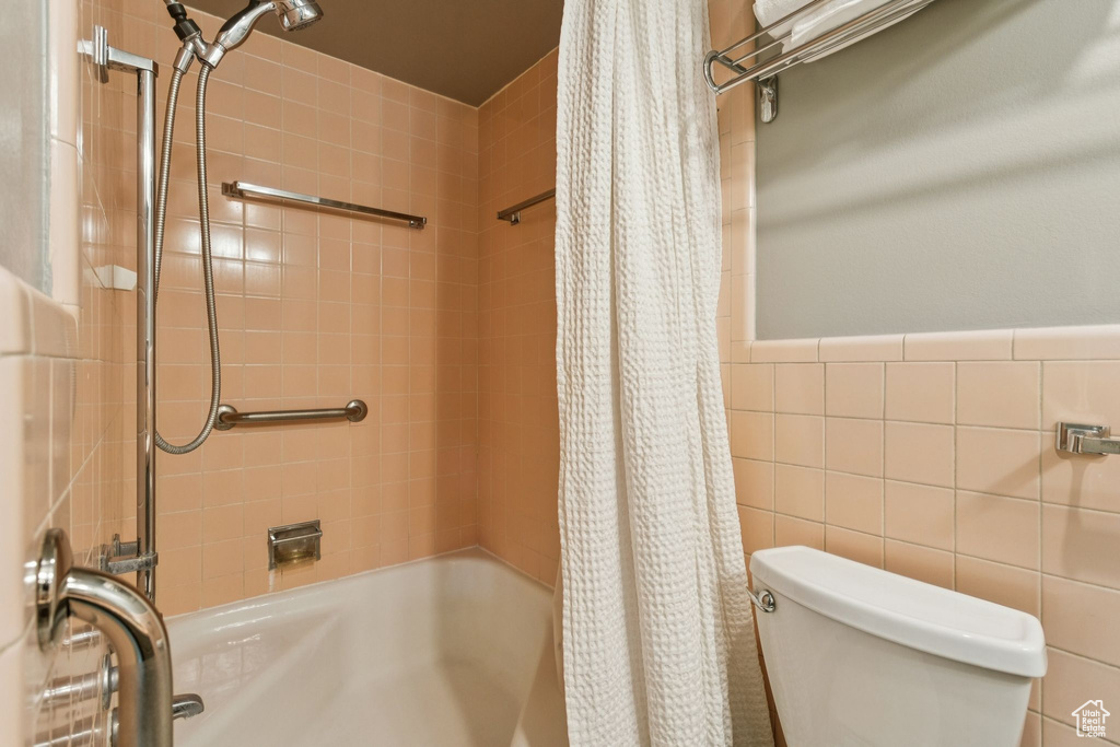 Bathroom with shower / bathtub combination with curtain and tile walls