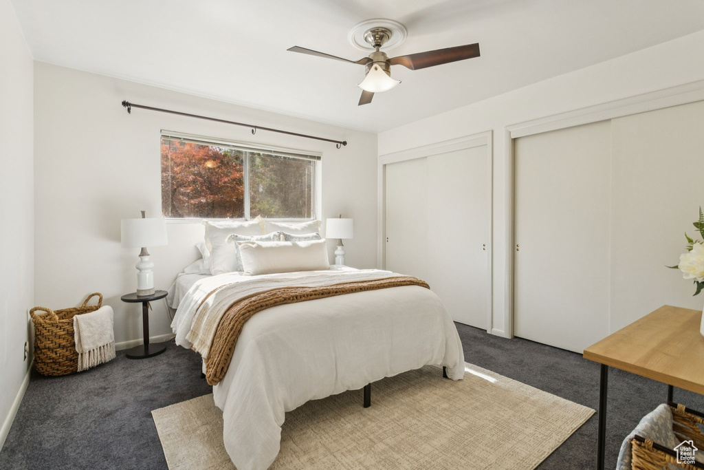 Bedroom with multiple closets, carpet flooring, and ceiling fan