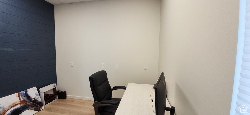 Office space featuring wooden walls and light wood-style flooring